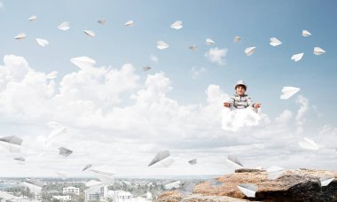 Genç küçük çocuk gözleri koruma kapalı ve seyir arka plan üzerinde şehir manzaralı havada bulut üzerinde meditasyon sırasında konsantre.