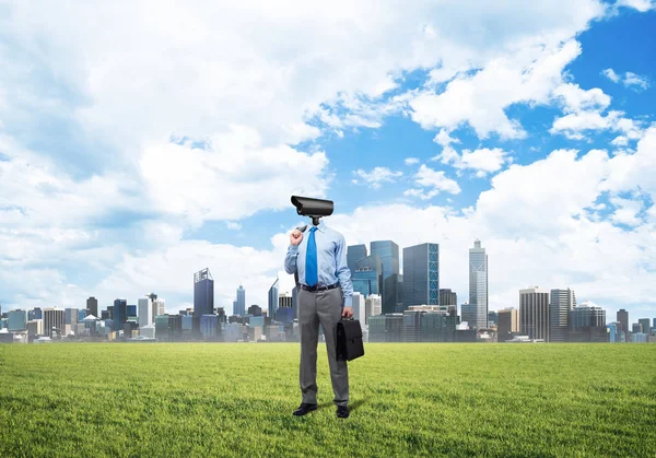 Kameramann steht auf grünem Gras vor modernem Stadtbild — Stockfoto