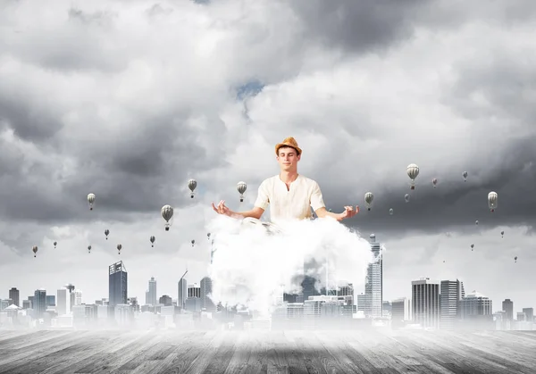 目を保つ白い服の男が閉じられ 都市の景観を望む雲に瞑想と背景に気球を飛行しながら集中して見て — ストック写真