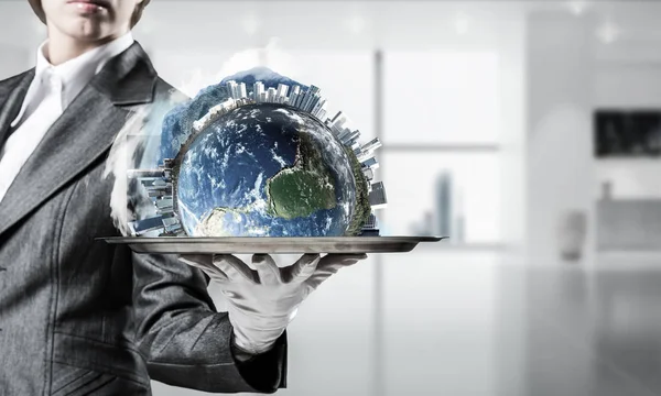 Hand of waitress presenting Earth globe on tray.