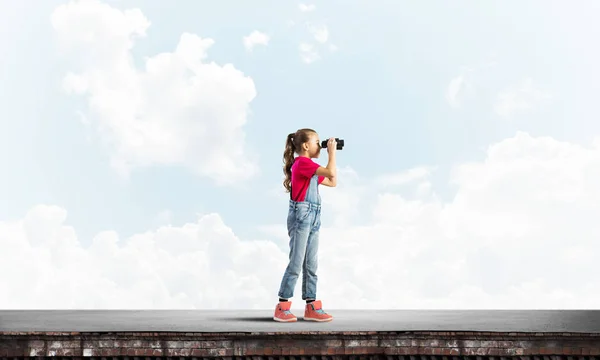 Χαριτωμένο Κορίτσι Της Σχολικής Ηλικίας Στην Οροφή Κτιρίου Ψάχνει Κιάλια — Φωτογραφία Αρχείου