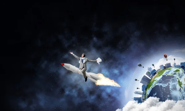年轻商人的概念形象在火箭与行星地球和开放空间的背景下飞行 这个形象的元素是由美国宇航局提供的 — 图库照片