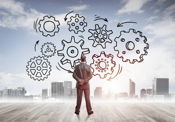 Modern şehre bakan ve vites düzeneği çizen işadamlarının arka planı