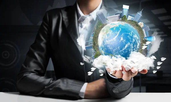 İş binaları ile dünya küre elinde tutmak ve kağıt uçak uçan takım elbiseli adamı closeup. Bu görüntü unsurları Nasa tarafından döşenmiştir.