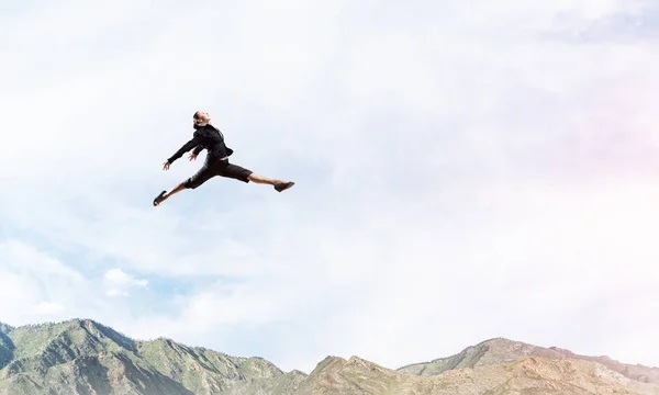 Attractive business woman in suit jumping in the air as symbol of active life position. Skyscape with sunlight and nature view on background. 3D rendering.