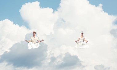 Genç çift gözleri koruma kapalı ve seyir ile bulutlu gökyüzü arka plan üzerinde havada bulutlar üzerinde meditasyon sırasında konsantre.