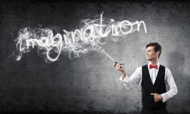 Akıllı-rahat, kendinden emin ve genç işadamı yatay atış yasaktır boru gri karanlık duvar ve duman arka plan üzerinde yapılan hayal word karşı dururken giymek.