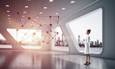 Kendine güvenen tıbbi sanayi çalışanı beyaz hastane binası içinde duran ve siyah ağ yapısı inceleyerek. Medikal endüstri için modern teknolojiler