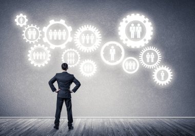 İş adamının çizilmiş dişli mekanizmasıyla duvara baktığı arka plan