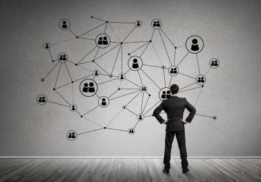 Arkadan görünüşü çizilmiş sosyal bağlantı kavramı ile duvara bakarak işadamı