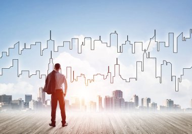 İşadamı arkasını dönüp modern iş merkezinin siluetine bakıyor.