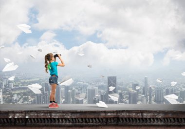 Dürbünle bakan, okul çağındaki sevimli kız çatıyı inşa ediyor.