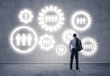 İş adamının çizilmiş dişli mekanizmasıyla duvara baktığı arka plan