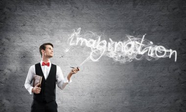 Akıllı-rahat, kendinden emin ve genç işadamı yatay atış yasaktır boru gri karanlık duvar ve duman arka plan üzerinde yapılan hayal word karşı dururken giymek.