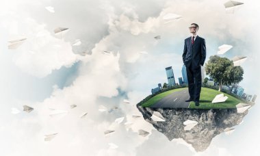 Mavi gök yeşil yüzen ada üzerinde duran zarif emin iş adamı