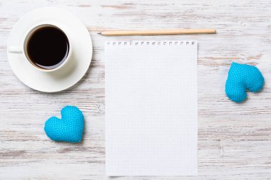 Kahve fincanı not defteri kalem ve ahşap yüzeyde iki kalp