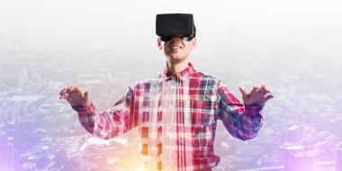 Sanal gerçeklik kulaklığı olan genç bir adam ya da şehrin arka planında 3 boyutlu gözlüklü.