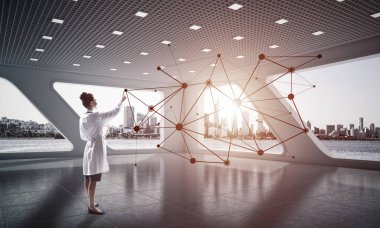 Beyaz hastane ofisi içinde ayakta iken sosyal ağ yapısı ile çalışan beyaz Tıbbi üniforma genç kadın doktorun yatay çekim. Medikal Sanayi