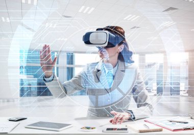 Dijital medya yapısı içinde office dururken ile sanal gerçeklik kulaklık kullanarak takım elbiseli güzel ve genç iş kadını. Güncel güvenlik teknolojileri