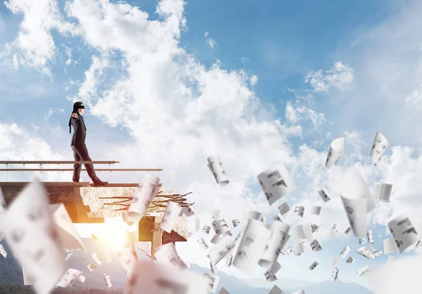 Kağıtları kocaman bir boşluk ile beton köprü üzerinde gizli tehditler ve riskler sembolü olarak uçan arasında blindfolded yürüyüş iş adamı. Hava ve doğa arka planda görüntüleyin. 3D render.