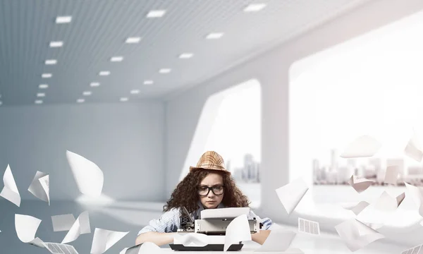 Jovem Escritora Chapéu Óculos Usando Máquina Digitação Enquanto Senta Mesa — Fotografia de Stock