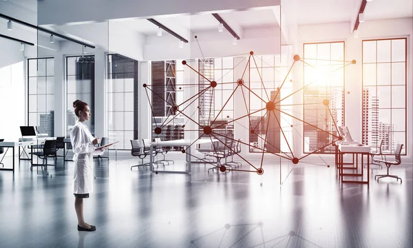 Confident medical industry employee standing inside white hospital building and examining black network structure. Modern technologies for medical industry