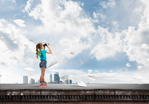 Dürbünle bakan, okul çağındaki sevimli kız çatıyı inşa ediyor.
