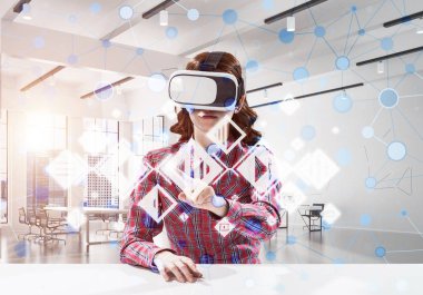 Parlak ofis binası içinde otururken sanal gerçeklik kulaklık ve medya arayüzü kullanarak damalı gömlek genç ve güzel kadın yatay çekim.