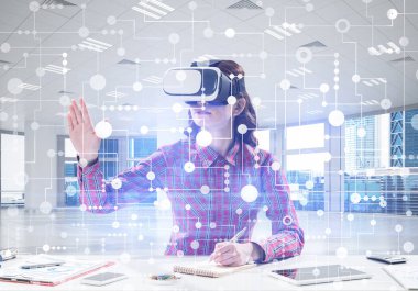 Vr gözlük kullanarak kırmızı damalı gömlek güzel ve genç kadın parlak ofis binası içinde otururken dijital medya arayüzü ile interracting. Sanal gerçeklik cihazı
