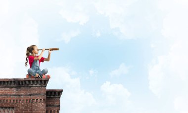 Evin çatısında oturan ve dürbüne bakan tatlı bir kız.