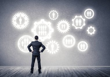 İş adamının çizilmiş dişli mekanizmasıyla duvara baktığı arka plan