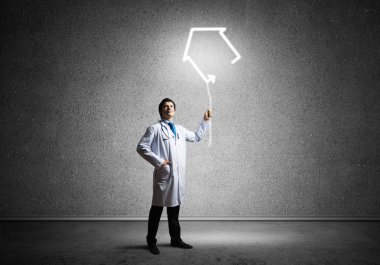 Arka planda gri koyu duvara karşı dururken parlayan ev sembolü ile interracting beyaz tıbbi takım başarılı doktor kavramsal görüntü.
