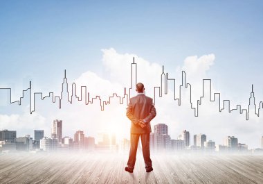 İşadamı arkasını dönüp modern iş merkezinin siluetine bakıyor.