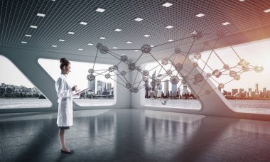 Beyaz hastane binası içinde ayakta iken sosyal ağ yapısını okuyan beyaz elbise emin kadın doktor yatay çekim. Medikal Sanayi konsepti