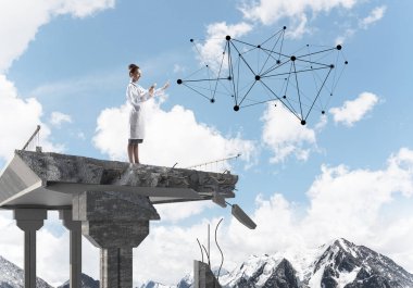 Kırık köprü sonunda akıllı telefon kullanarak beyaz üniforma ve sosyal medya ağ yapısı ile interracting emin kadın doktor. Tıbbi endüstri konsepti. Arka planda peyzaj görünümü