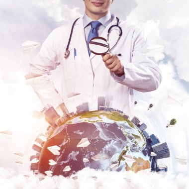 Beyaz takım ve dünya küre ile bulutlu gökyüzü arka plan üzerinde büyüteç aracılığıyla keşfetmek boynunda steteskop profesyonel adam doktor görüntü kırpılmış. Tıp sektöründe kavramı. Nasa tarafından döşenmiş bu görüntü unsurları