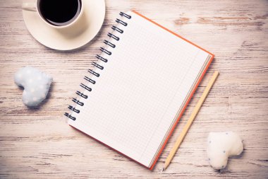 Kahve fincanı not defteri kalem ve ahşap yüzeyde iki kalp