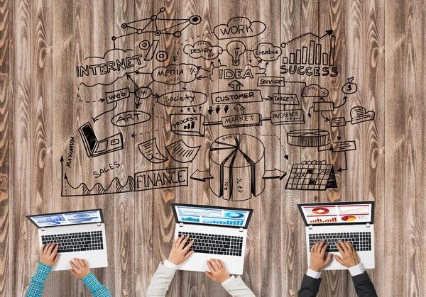 Masada oturan ve alet kullanan iş adamlarının en iyi görüntüsü.