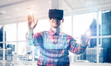 Giyen adam ekose desenli gömlek ve sanal kulaklık medya ekran Masası ile çalışma