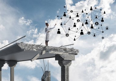 Kırık köprü sonunda beyaz üniforma ayakta genç kadın doktor ve sosyal medya ağ yapısını inceleyerek. Tıbbi endüstri konsepti. Arka planda peyzaj görünümü