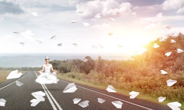 Genç kadın gözleri koruma kapalı ve seyir ile güzel ve nefes kesici manzara arka plan üzerinde bulut yukarıda yolun üzerinde meditasyon sırasında konsantre.