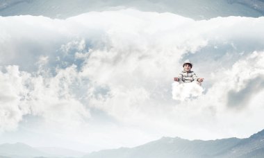 Genç çocuk gözleri koruma kapalı ve seyir bulut doğa dünyalar arasında havada meditasyon sırasında konsantre.