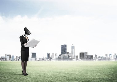 Kamera modern şehrin karşı yeşil çimenlerin üzerinde duran kadın başlı