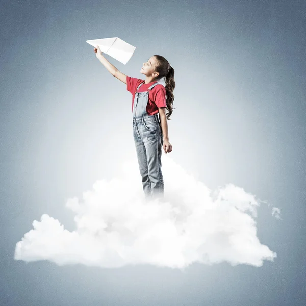 Χαριτωμένο Κορίτσι Στέκεται Στο Σύννεφο Και Ρίχνουν Χάρτινο Αεροπλάνο — Φωτογραφία Αρχείου