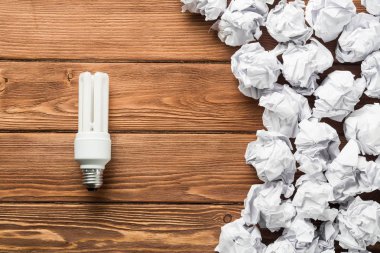 Ahşap masa üzerinde atık kağıt ampul ile ideolojik kavram