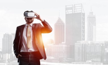 Genç yakışıklı iş adamı cityscape arka plan karşı sanal kask
