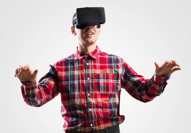 Ekose desenli gömlek gri arka plan karşı sanal kask giymiş genç adam