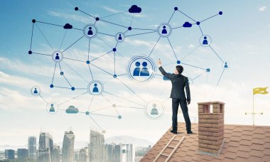 Delikanlı çatıda dikiliyor ve bağlantı hatları çiziyor. Karışık ortam