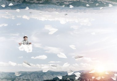 Genç küçük çocuk gözleri koruma kapalı ve seyir bulut uçan kağıt uçaklar arasında ve doğa dünyalar arasında üzerinde meditasyon sırasında konsantre.