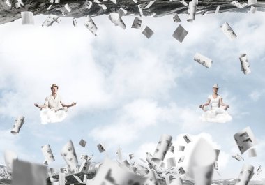 Genç çift gözleri koruma kapalı ve seyir bulutlar arasında kağıtları uçan ve doğa dünyalar arasında üzerinde meditasyon sırasında konsantre.